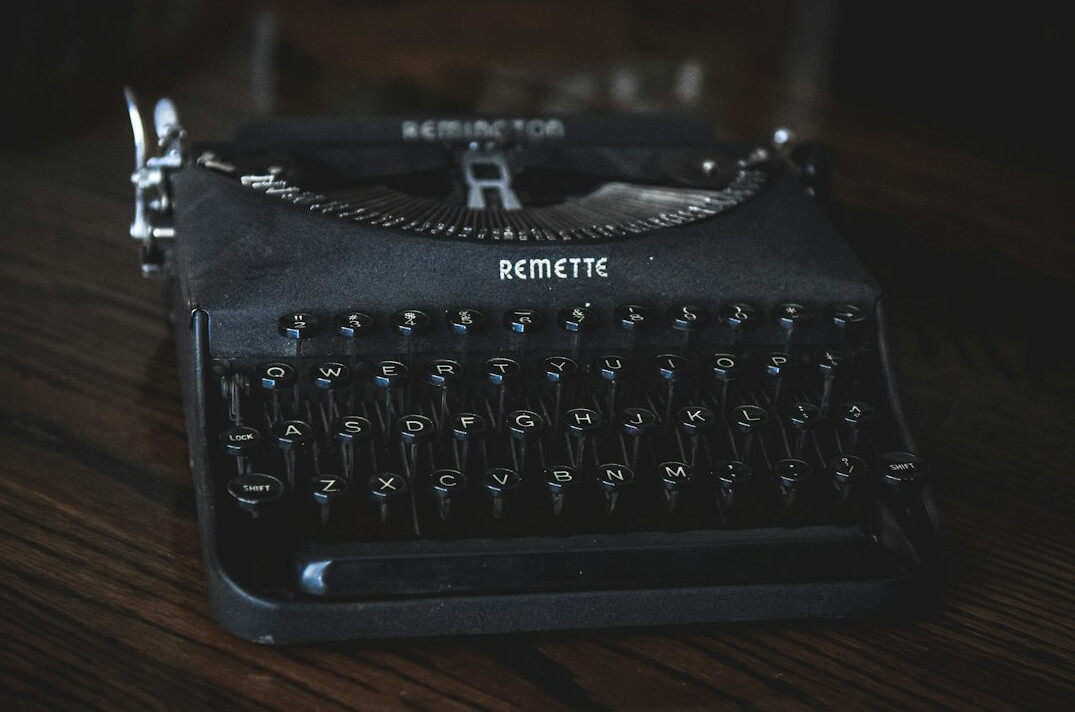 Vintage typewriter with a sheet of paper on a wooden desk